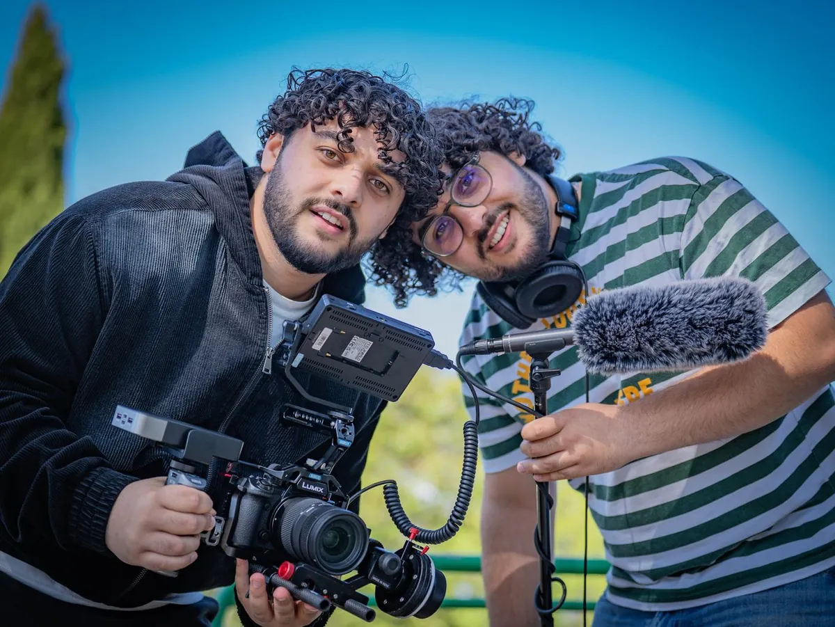 Deux membres de l'équipe Les Prods, caméra et micro en main, sur un tournage